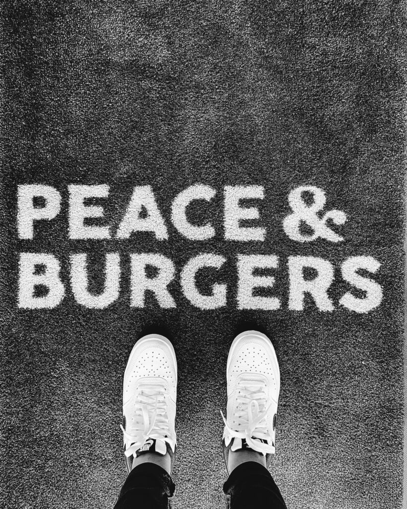 Standing above Peace & Burgers sign