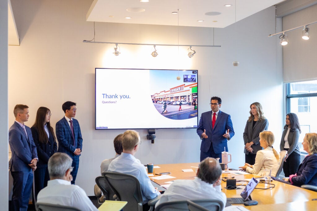 Intern Presenting with group to ELT sitting at Boardroom Table 