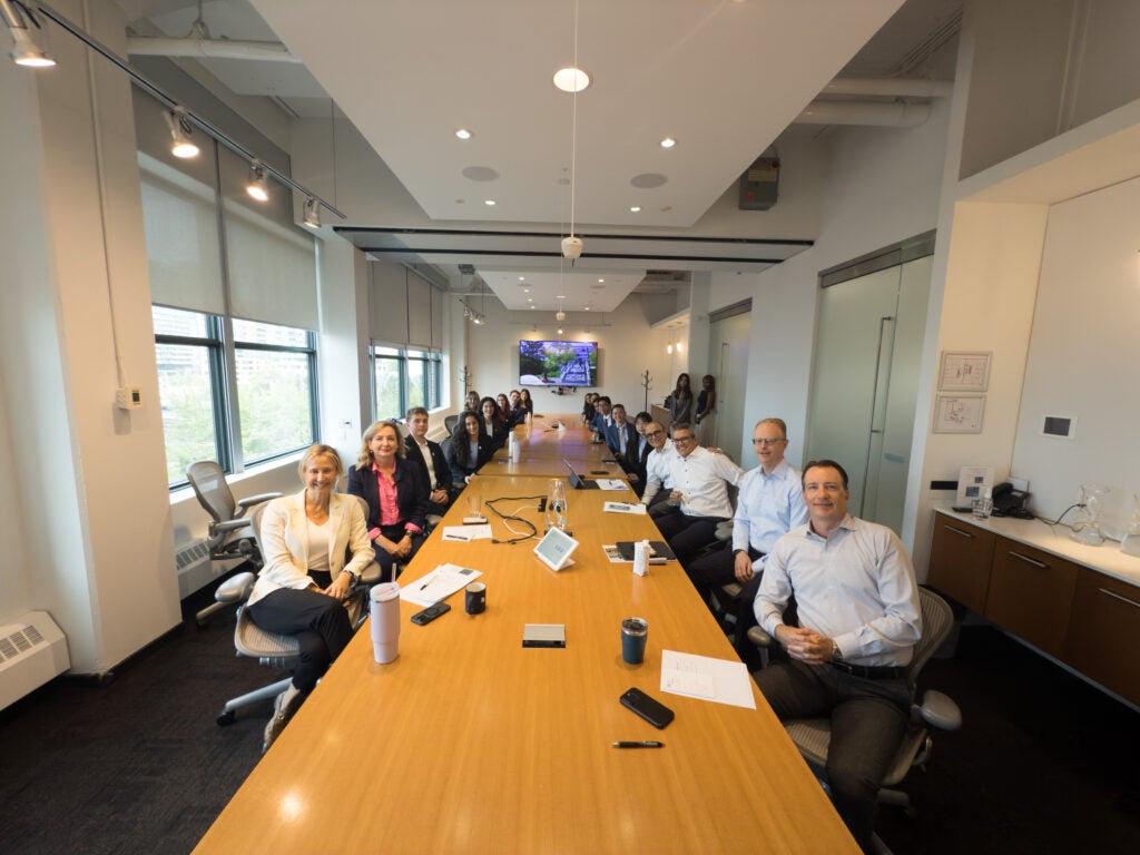 Interns and ELT group photo sitting at boardroom table 