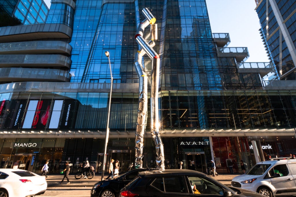 Facade of  Nike, Mango and Avant at One Bloor east with people and cars passing by 