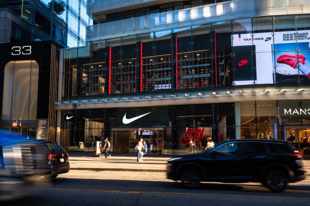 facade of Nike at One Bloor East with people and cars passing by in front