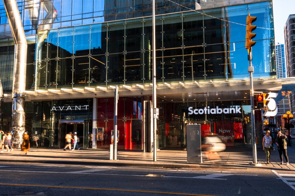 Facade of Sociabank and Avant with people and cyclists passing by 