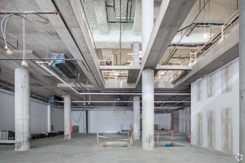 Interior of the shell space of Nike at One Bloor East with concreter floors and construction material 