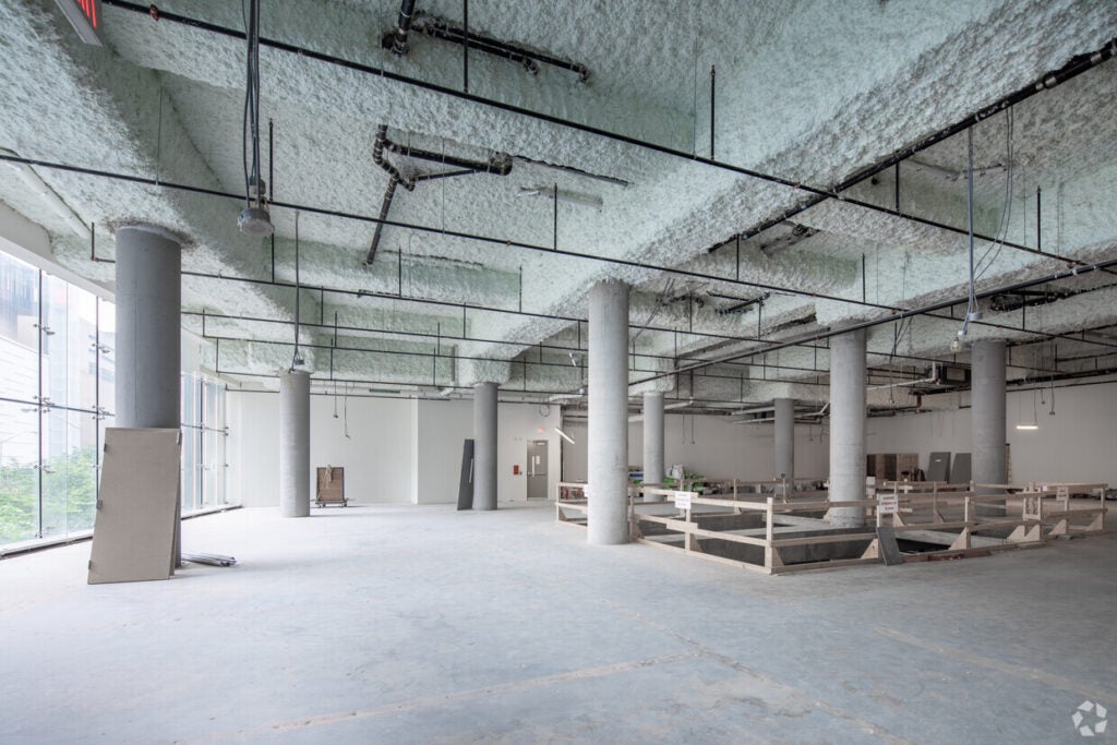 Interior of the shell space of Nike at One Bloor East with concreter floors and construction material 